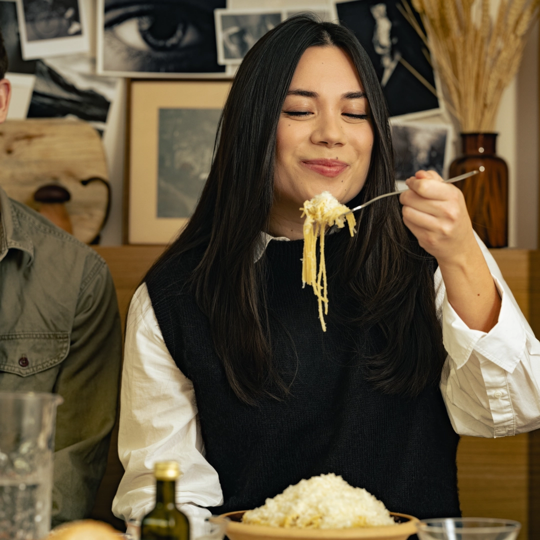 Woman eating spaghetti with lots of cheese on it - Ny Studio