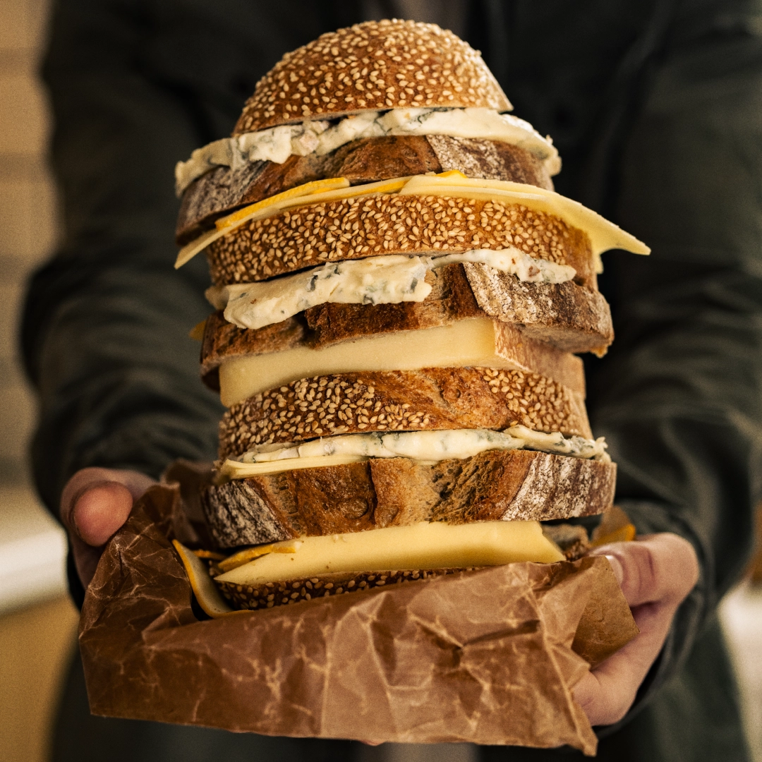 Man holding a high sandwich wich cheese - Ny Studio
